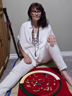 Eileen sitting on a grass mat on the floor with her Bone & Curiosity reading set between her legs.